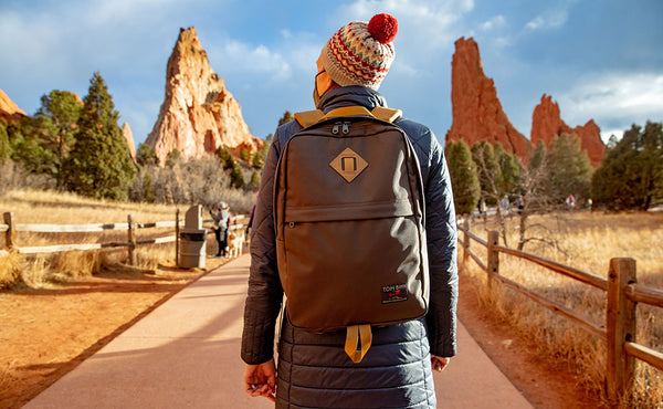 Person walking outdoors in a scenic area wearing the Guide's Edition Paragon in Ursa brown.